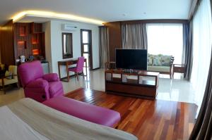 a living room with a couch and a tv in a room at Skinetics Wellness Center Boutique Hotel in Iloilo City