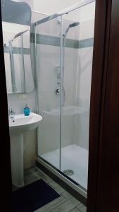 une douche avec une porte en verre à côté d'un lavabo dans l'établissement La Gardenia, à Licodia Eubea