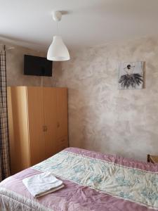 a bedroom with a bed and a dresser and avertisement at Le Chemin Neuf in Gréoux-les-Bains