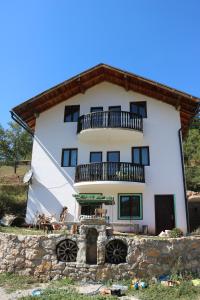 a large white building with a balcony at Eco Camp Dzogaska Vrela in Pljevlja