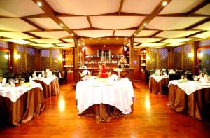 une salle à manger avec des tables et des nappes blanches dans l'établissement Hotel Villa Elisabetta, à Galatina