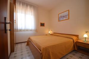pokój hotelowy z łóżkiem i oknem w obiekcie Villaggio Orchidee w Bibione +11 zdjęć