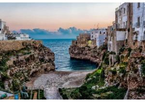 コンヴェルサーノにあるMansarda romantica "Il nido delle rondini"の崖の上の建物を眺める海
