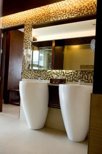 a bathroom with two white sinks and a mirror at Skinetics Wellness Center Boutique Hotel in Iloilo City