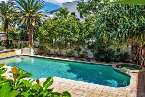 a swimming pool in a yard with palm trees at Indigo Blue in Gold Coast
