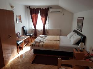 1 dormitorio con cama, escritorio y ventana en Studio Zlatnik, en Arandjelovac
