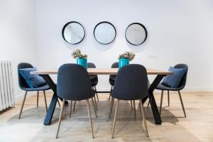 mesa de comedor con sillas y espejos en la pared en Moncloa Luxury, en Madrid