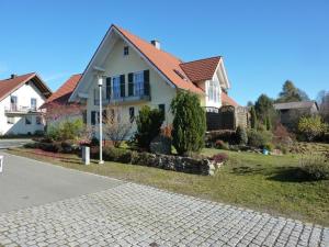 Biały dom z czerwonym dachem w obiekcie Ferienwohnung Aschka w mieście Schönsee