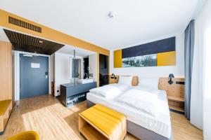 - une chambre avec un grand lit et un lavabo dans l'établissement mk | hotel rüsselsheim, à Rüsselsheim
