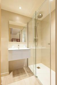 La salle de bains est pourvue d'un lavabo et d'une douche. dans l'établissement Hotel Restaurant des Maures, à Collobrières