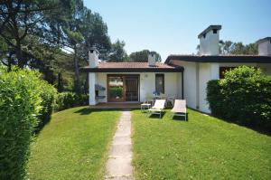 ビビオーネにあるVillaggio Club dei Piniの小さな白い家(椅子付)と庭