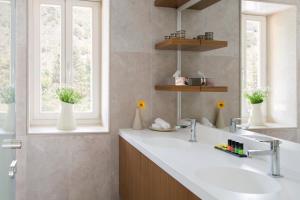 a bathroom with a white sink and two windows at Casale Panayiotis in Kalopanayiotis
