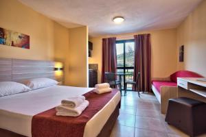 a hotel room with a bed with towels on it at Luna Holiday Complex in Mellieħa