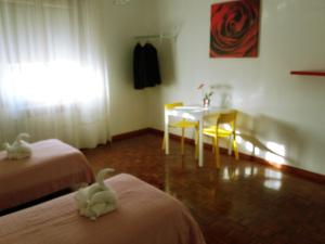 a room with two beds and a table and chairs at Bed & Breakfast Anzola in Anzola dell'Emilia