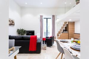 a living room with a black couch and a table at Alohamundi Marqués de Paradas in Seville