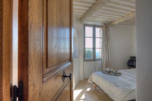 1 dormitorio con 1 cama y puerta de madera grande en La Pourtoune, en Saint-Paul-de-Vence