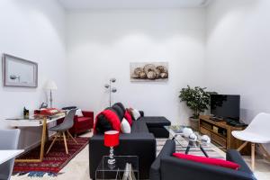 a living room with a black couch and red pillows at Alohamundi Marqués de Paradas in Seville