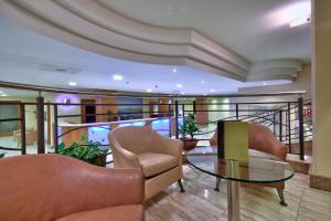a lobby with chairs and a glass table at Luna Holiday Complex in Mellieħa