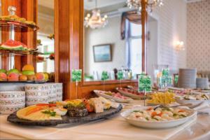 a buffet with plates of food on a table at SEETELHOTEL Villa Esplanade mit Aurora in Heringsdorf