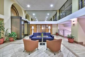 a lobby with a blue couch and chairs at Luna Holiday Complex in Mellieħa