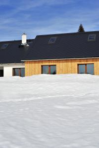 une maison avec beaucoup de neige devant elle dans l'établissement Apartmány no.823, à Bublava