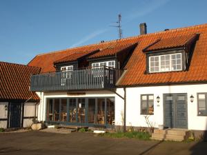 a white house with an orange roof at Bobergs på Hamngården in Brantevik