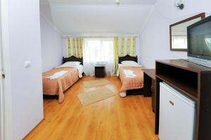 Habitación pequeña con 2 camas y TV de pantalla plana. en Shklo Motel, en Shklo