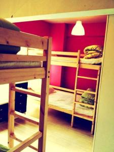 two bunk beds in a room with a red wall at Hong Kong CoLiving Space in Hong Kong