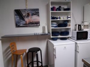 a kitchen with two chairs and a counter and a refrigerator at Room in Villa Emilia in Espoo