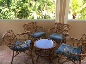 four chairs and a table with blue cushions on a porch at Gardenia Villa in Mont Choisy