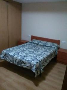 a bedroom with a bed with a blue and white comforter at APARTAMENTO PERGAR I - 4 PERSONAS DESDE 35e-WIFI in Granada