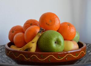 a bowl of fruit with apples oranges and bananas at B&B Casa Agradable in Arenas