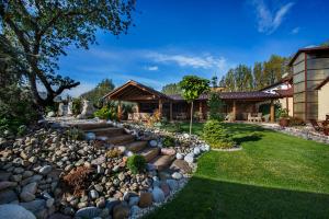 a garden with rocks and a house at Wellness Penzión Vila Mery in Poprad