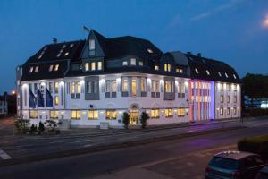 a large white building with an american flag on it at Hotel Moerser Hof in Moers