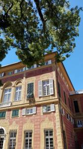 ein großes Backsteingebäude mit weißen Fenstern und einem Baum in der Unterkunft Grand Hotel Villa Balbi in Sestri Levante