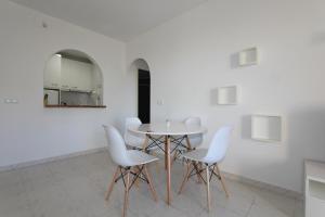 トレビエハにあるLomas Blancas 4550の白いダイニングルーム(テーブル、白い椅子付)