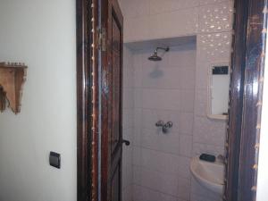 uma casa de banho com um chuveiro, um lavatório e um WC. em Hotel Coeur de Mogador em Essaouira