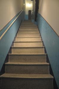 un conjunto de escaleras en un pasillo con una pared azul en Piccolo monolocale accanto al Duomo, en Cefalú