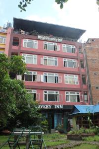 un edificio rojo con un letrero que lee posada de terapia de hospital en Hotel Discovery Inn, en Katmandú