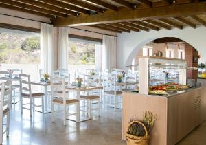 a restaurant with white chairs and tables and a buffet at Casale Panayiotis in Kalopanayiotis