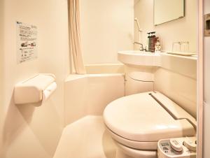 a white bathroom with a toilet and a sink at Guest House Wagokoro in Tokyo