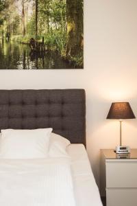 a bedroom with a bed and a table with a lamp at Spreehaus-Apartments in Lübben