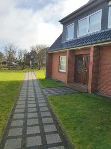 a brick house with a walkway in front of it at Falkennest 1 in Westerland