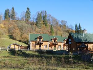 a large wooden house with a green roof at Готель Добрій in Vorokhta