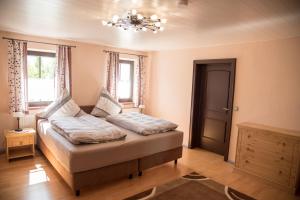 1 dormitorio con 1 cama con lámpara de araña en Ferienhaus Schmiedehof, en Hitzing