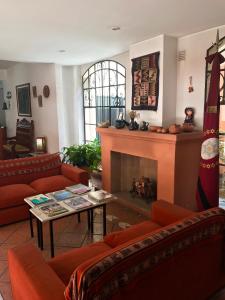 a living room with red couches and a fireplace at Altoparque Hotel Salta in Salta