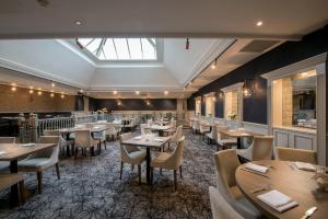 un ristorante con tavoli, sedie e lucernario di Westmead Hotel Bar & Restaurant a Hopwood