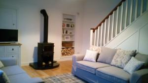 a living room with a couch and a wood stove at SunnySide-Cottage in Ennistymon