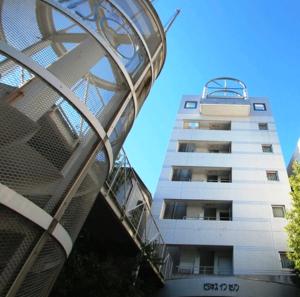 een hoog gebouw naast een gebouw bij Select Inn Nagoya Iwakura Eki-mae in Iwakura