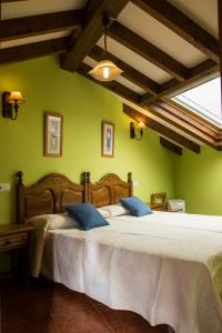- une chambre avec 2 lits aux murs verts dans l'établissement Apartamentos la Regoria, à Arenas de Cabrales